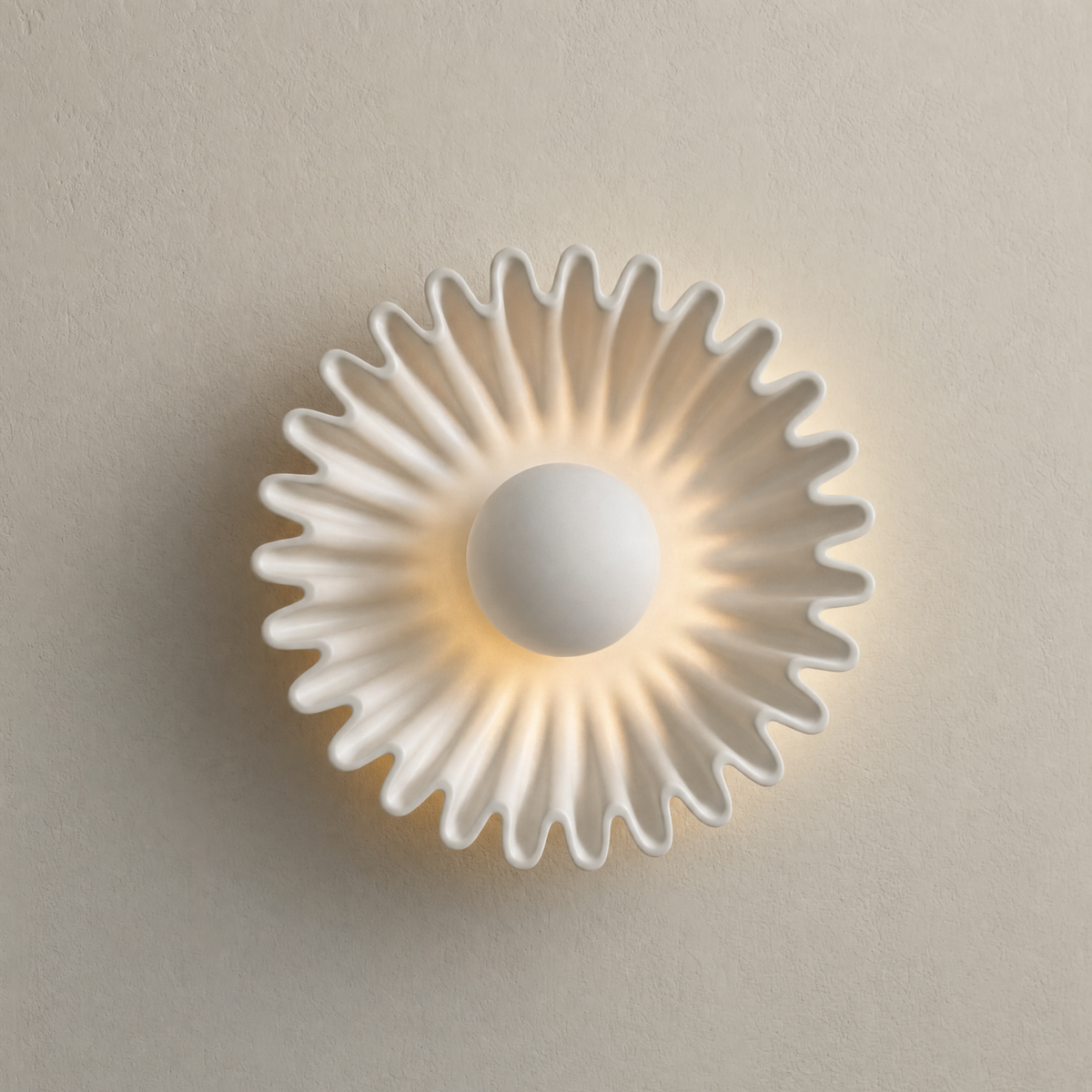 Calla ceramic wall sconce in White glaze, lit on a cream wall